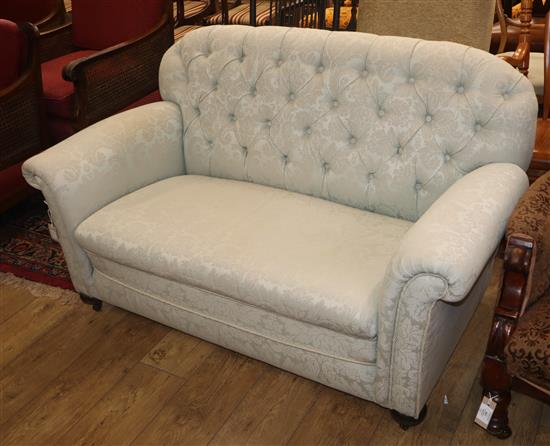 A two-seater settee covered in eau-de-nil buttoned brocade W.144cm